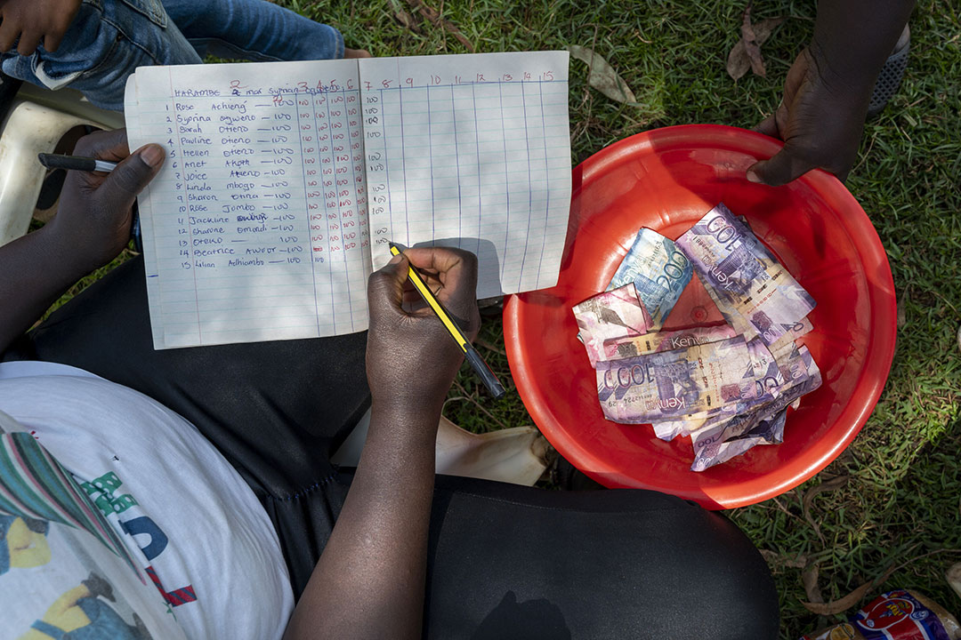 A community member documents finances for members enrolled in a saving and lending program.