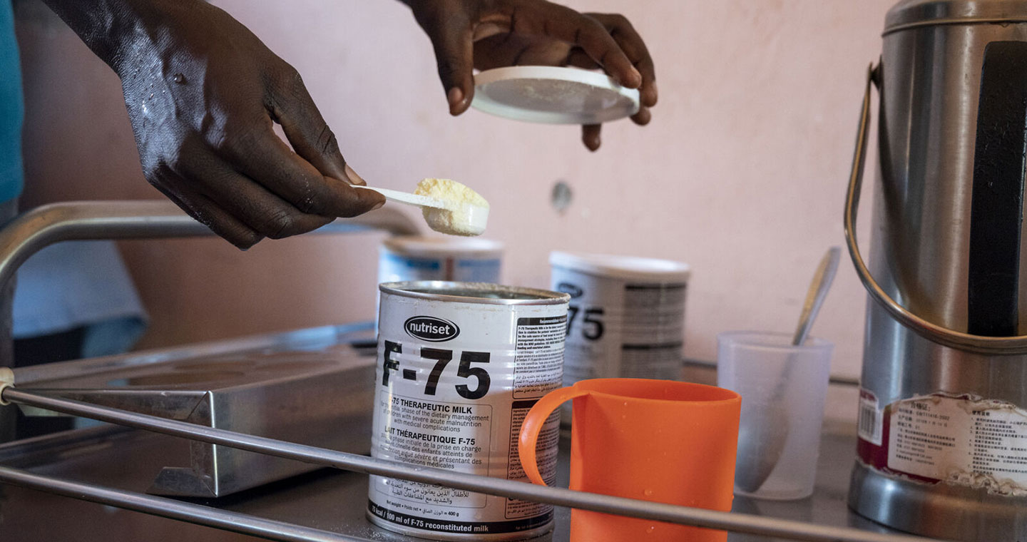 A health worker prepares a nutrition supplement to treat malnutrition.