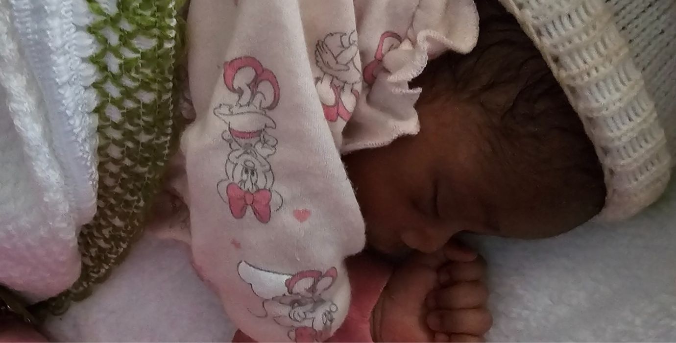 A premature newborn sleeps peacefully.